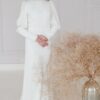 KIN jsou skromné svatební šaty z hedvábí v barvě ivory: lodičkový výstřih vpředu, hluboké V na zádech, knoflíčky a dlouhé rukávy s jemným řasením v ramenou.